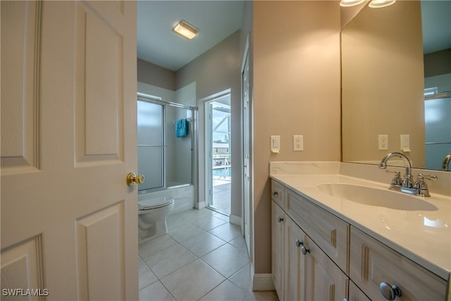 full bathroom featuring tile patterned floors, vanity, toilet, and enclosed tub / shower combo