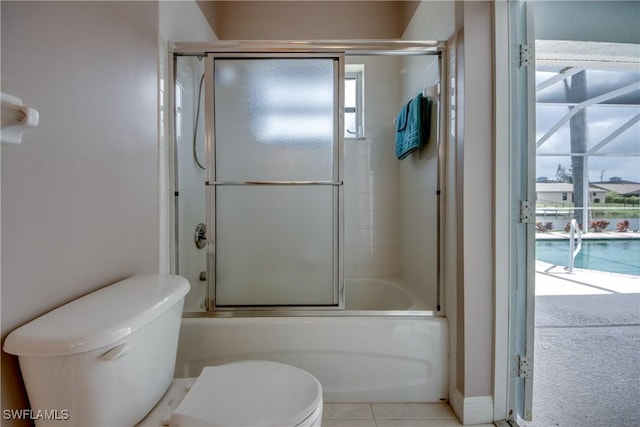 bathroom with a wealth of natural light, tile patterned flooring, enclosed tub / shower combo, and toilet