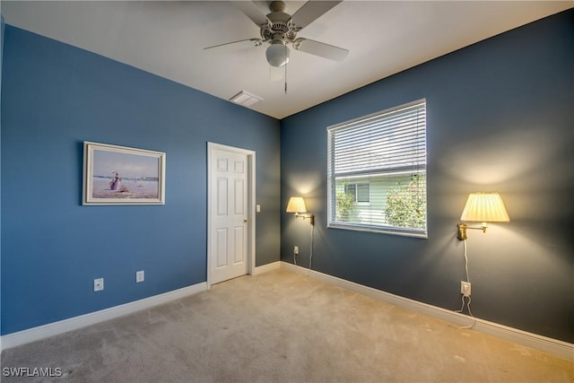 carpeted spare room with ceiling fan