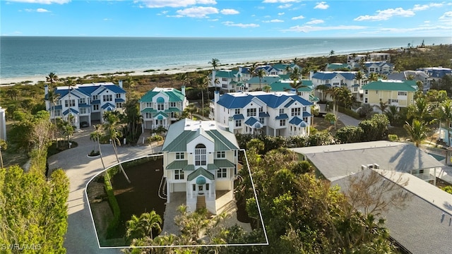 drone / aerial view featuring a beach view and a water view