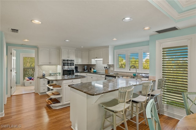 kitchen with white cabinets, light wood-type flooring, sink, and stainless steel appliances