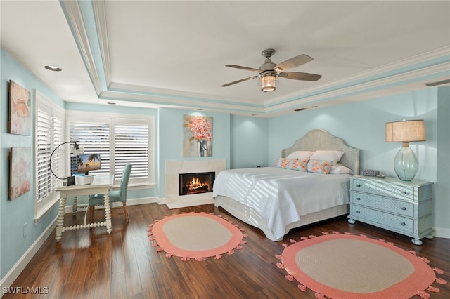 bedroom with a raised ceiling, ceiling fan, crown molding, and dark hardwood / wood-style floors