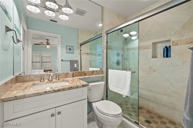 bathroom featuring ceiling fan, vanity, an enclosed shower, and toilet