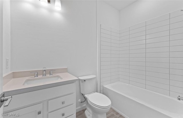 full bathroom with vanity, hardwood / wood-style flooring, toilet, and tiled shower / bath