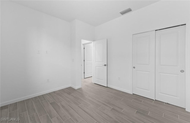 unfurnished bedroom featuring light hardwood / wood-style flooring and a closet