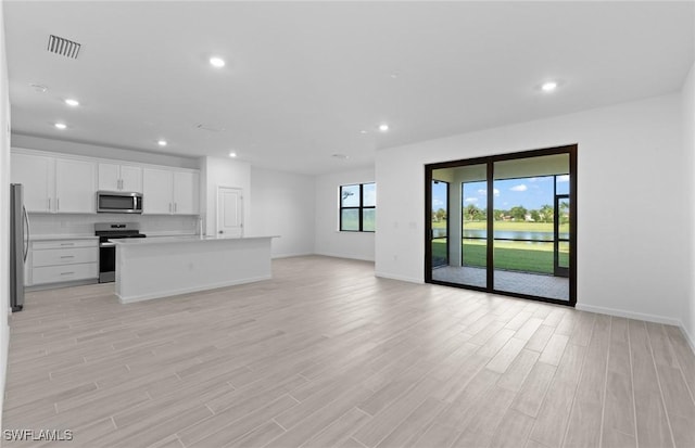 unfurnished living room with light hardwood / wood-style floors and sink