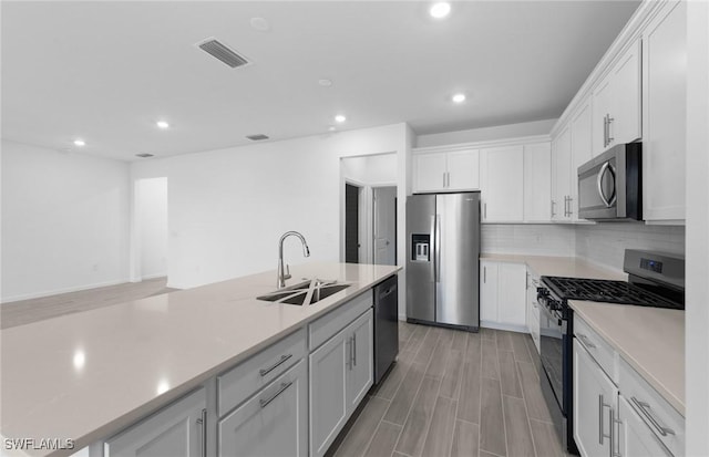 kitchen featuring backsplash, sink, white cabinetry, and stainless steel appliances