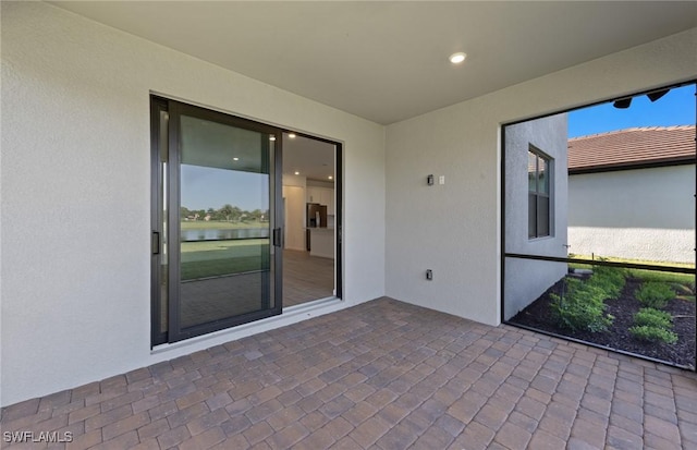 unfurnished sunroom featuring a water view