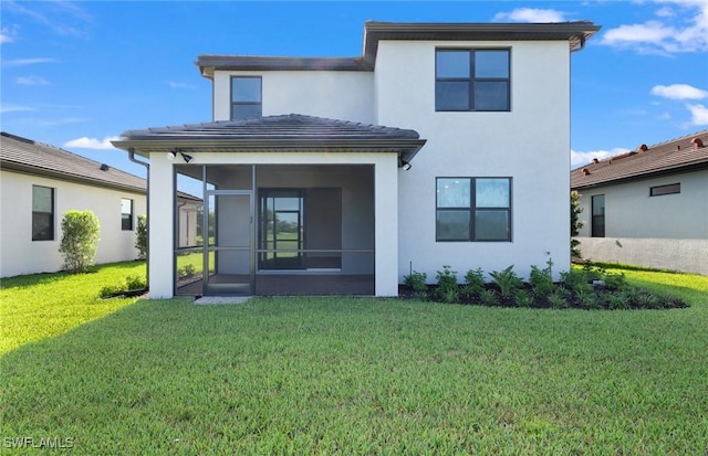 back of property featuring a sunroom and a lawn