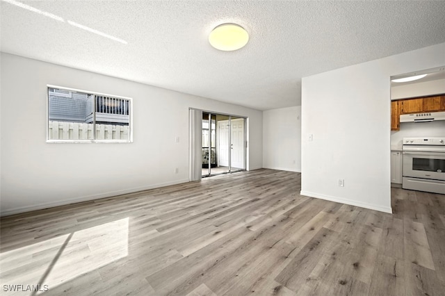 unfurnished living room with light hardwood / wood-style flooring and a textured ceiling