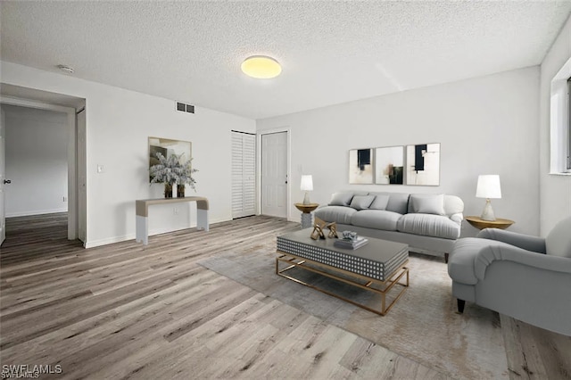 living room with wood-type flooring and a textured ceiling