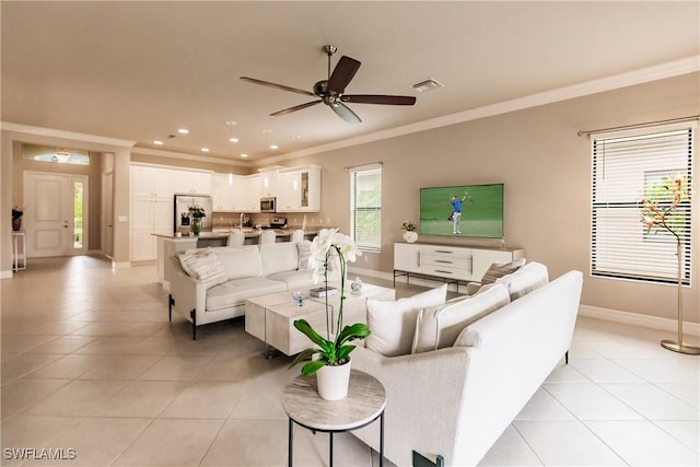 tiled living room featuring ceiling fan and ornamental molding