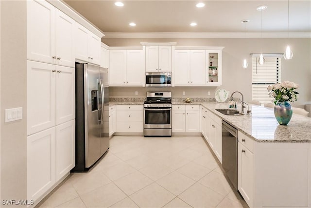 kitchen featuring sink, light stone counters, kitchen peninsula, decorative light fixtures, and appliances with stainless steel finishes