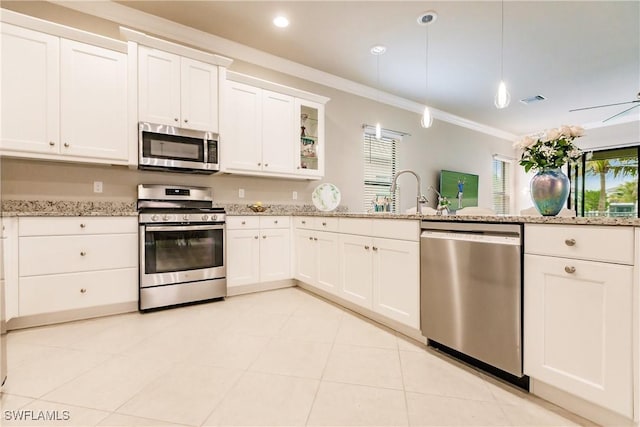 kitchen featuring white cabinets, crown molding, sink, decorative light fixtures, and stainless steel appliances