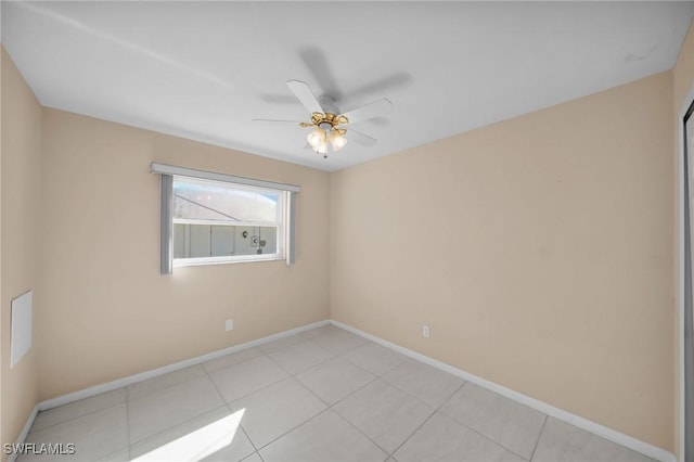 tiled spare room featuring ceiling fan