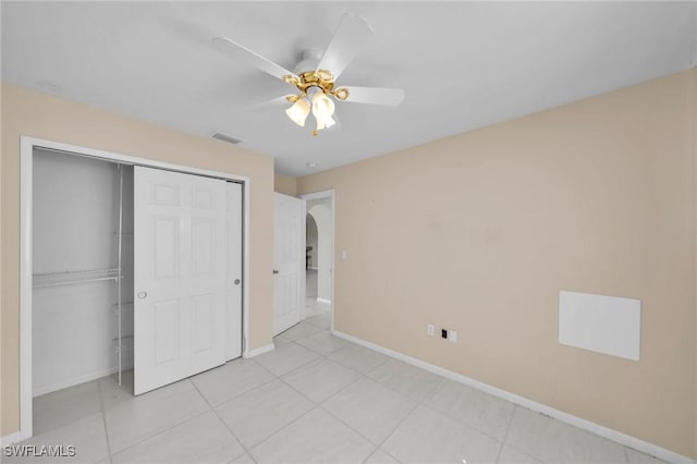 unfurnished bedroom featuring ceiling fan, light tile patterned flooring, and a closet