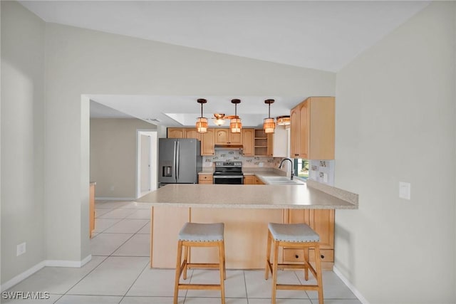 kitchen with kitchen peninsula, stainless steel appliances, lofted ceiling, and sink