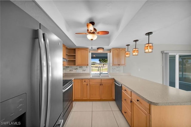 kitchen with kitchen peninsula, appliances with stainless steel finishes, ceiling fan, sink, and hanging light fixtures