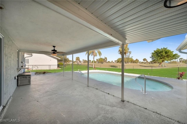 view of pool featuring a lawn, ceiling fan, and a patio