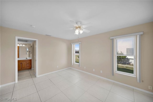 empty room with plenty of natural light, ceiling fan, and light tile patterned floors