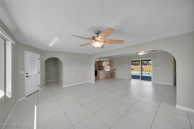 unfurnished living room with ceiling fan and light tile patterned flooring