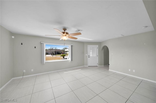 tiled empty room featuring ceiling fan