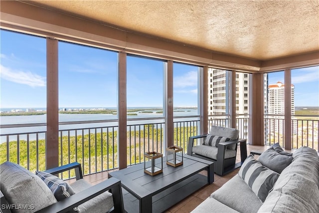 sunroom featuring a water view