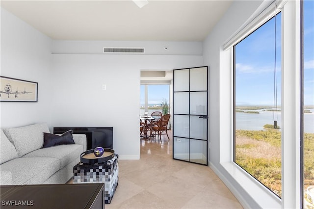 living room featuring a wealth of natural light and a water view