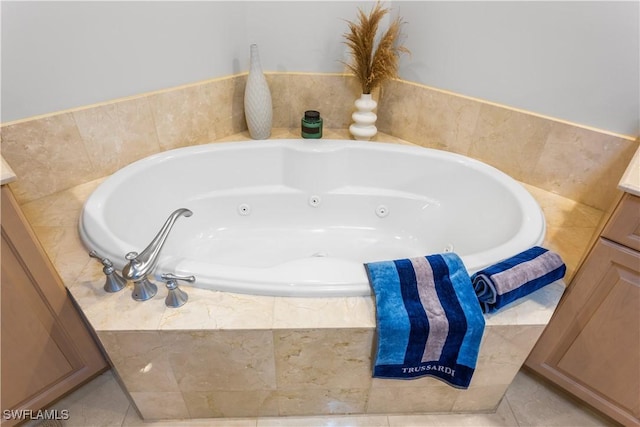 bathroom featuring tile patterned floors, tiled bath, and vanity