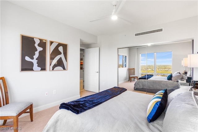 carpeted bedroom with ceiling fan and a closet