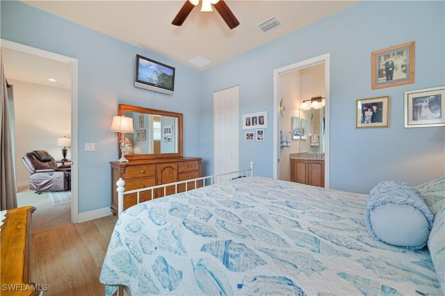 bedroom with ceiling fan, light hardwood / wood-style floors, and ensuite bath