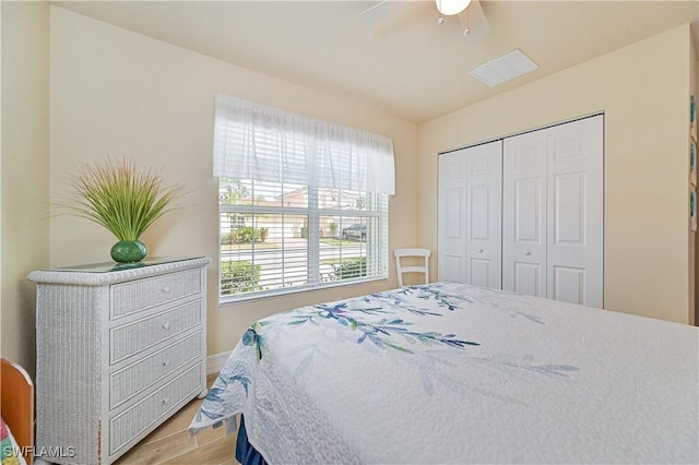 bedroom featuring ceiling fan, a closet, and light hardwood / wood-style floors