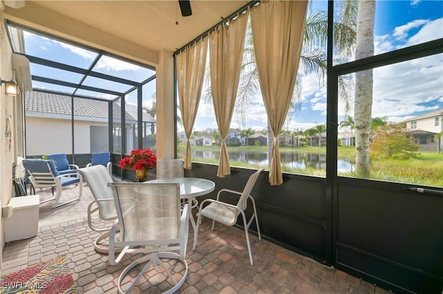 sunroom / solarium featuring a wealth of natural light, a water view, and ceiling fan