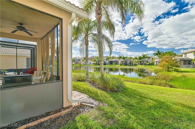 view of yard featuring a water view and ceiling fan