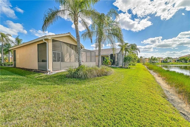 view of side of property featuring a yard, a water view, and a lanai