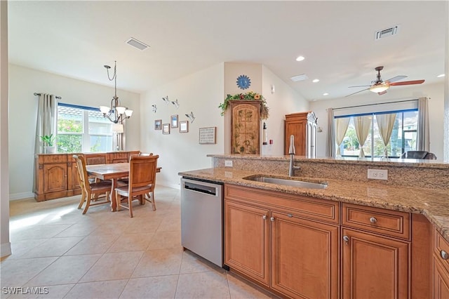 kitchen featuring light stone countertops, dishwasher, ceiling fan with notable chandelier, and sink