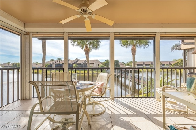 sunroom / solarium featuring a water view, a wealth of natural light, and ceiling fan