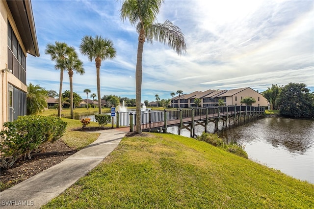 dock area featuring a lawn and a water view