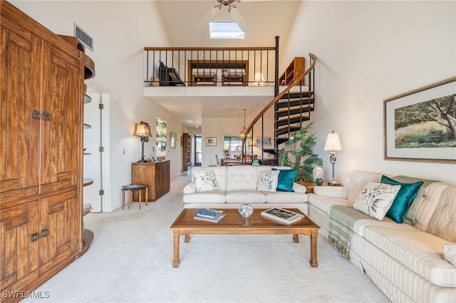 carpeted living room with high vaulted ceiling and ceiling fan