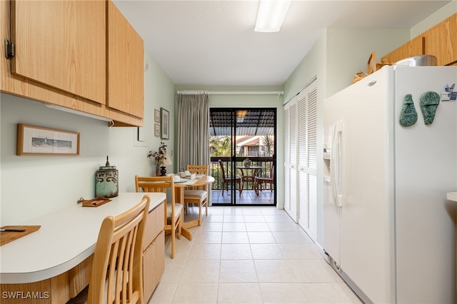 kitchen featuring light tile patterned floors and white refrigerator with ice dispenser