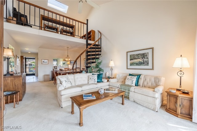 living room with light carpet, a towering ceiling, and ceiling fan