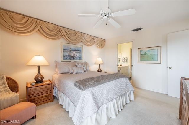 bedroom with ensuite bathroom, ceiling fan, and light colored carpet