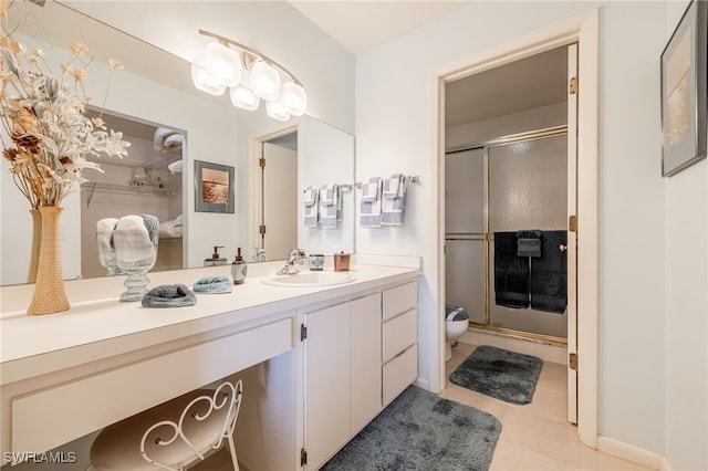 bathroom featuring tile patterned floors, a shower with door, and vanity