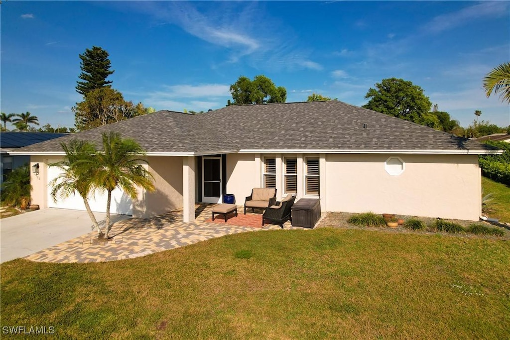 view of front of home with an attached garage, stucco siding, a front lawn, and a patio