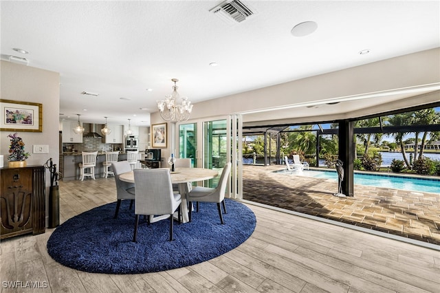 dining space featuring light wood-style floors, visible vents, a notable chandelier, and recessed lighting