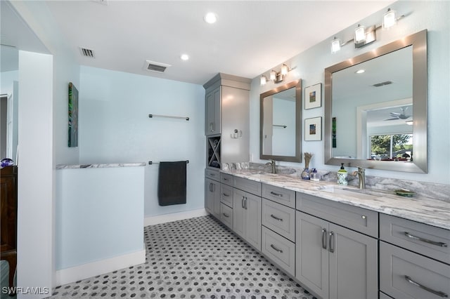 full bath with double vanity, a sink, and visible vents