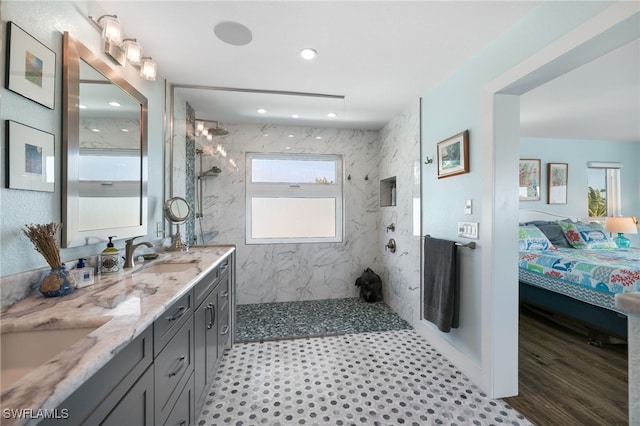 ensuite bathroom with double vanity, ensuite bath, a sink, and a marble finish shower