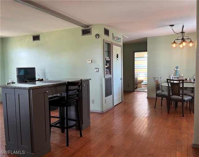 dining space with dark hardwood / wood-style floors and a chandelier