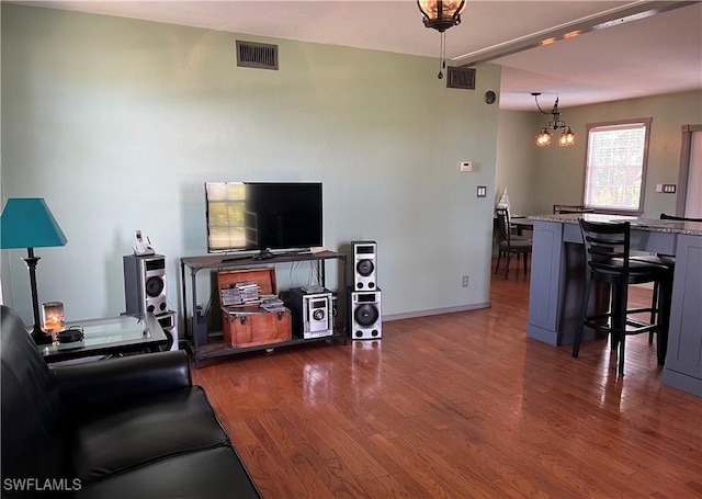 living room featuring an inviting chandelier and dark wood-type flooring