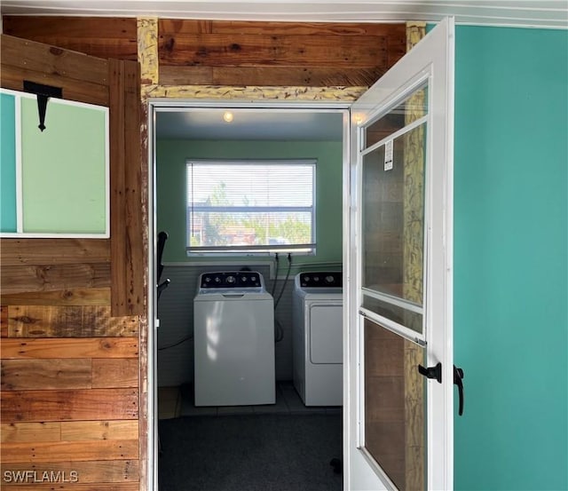 laundry room with washer and dryer and wood walls